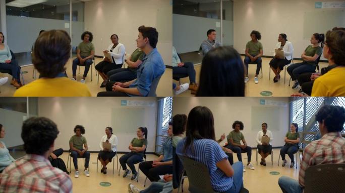 一群不同的学生坐在一个圆形与黑人女性顾问咨询会议