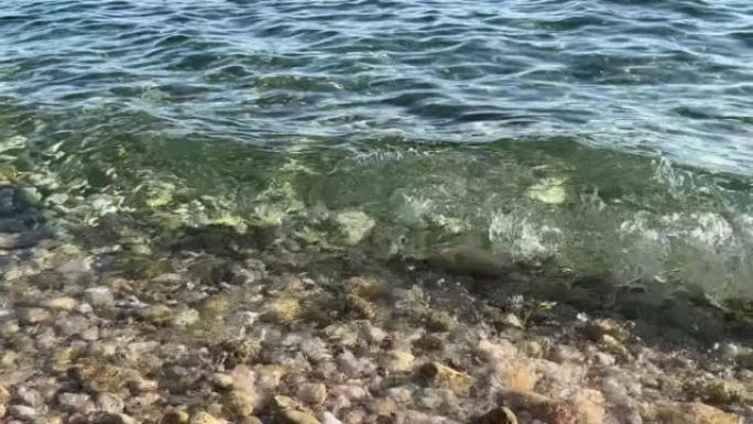 夏天在圆石滩上清澈的海浪。
