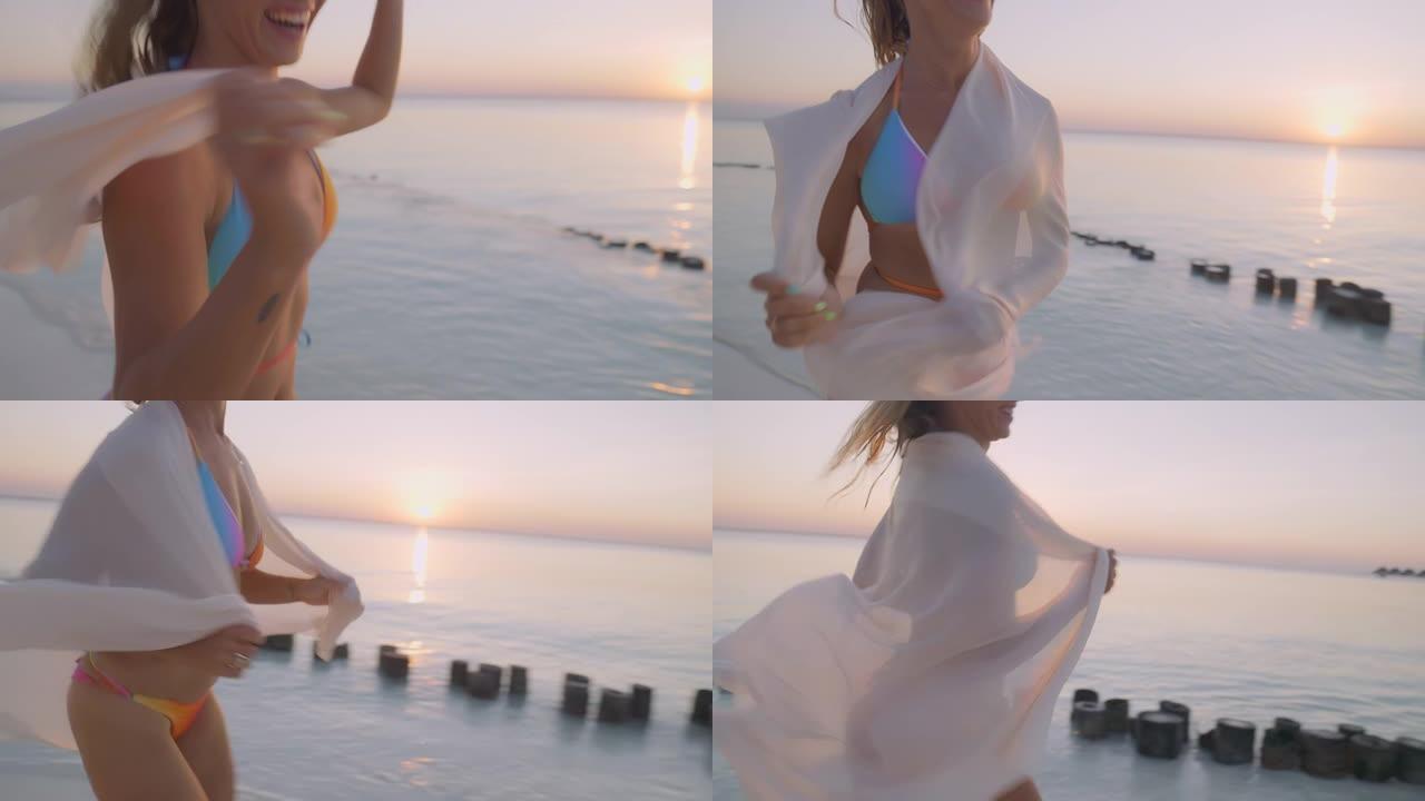 诱人的女人戴着精致的围巾跳舞。田园诗般的，日落时的热带海滩