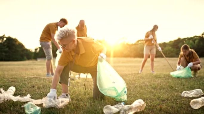 成熟的女人在大自然中与一群志愿者一起捡垃圾