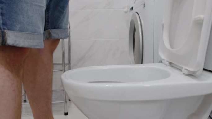 一名男子在洗手间的马桶里小便。尿失禁，前列腺炎和肾盂肾炎，泌尿外科的概念。
