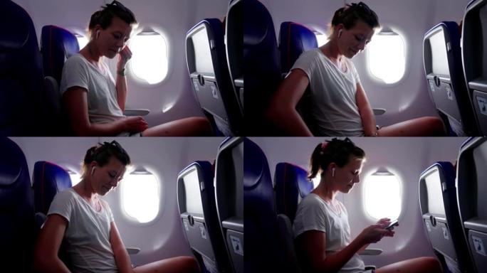 年轻女子在飞机上听音乐。