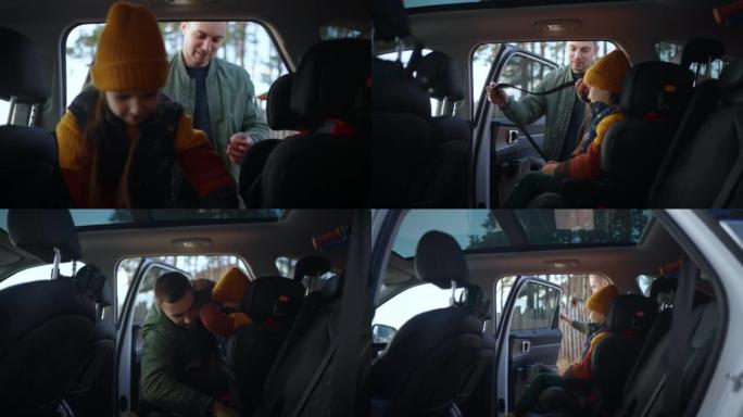 乘汽车旅行，父亲将女儿放在汽车上，并系好儿童座椅上的安全带。带孩子的汽车安全旅行