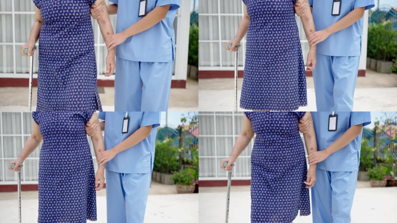 特写女护士帮助老人用拐杖走路，进行物理治疗。
