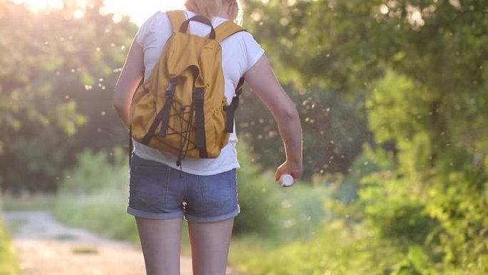 徒步旅行的妇女使用驱蚊剂防蚊和蜱。户外护肤