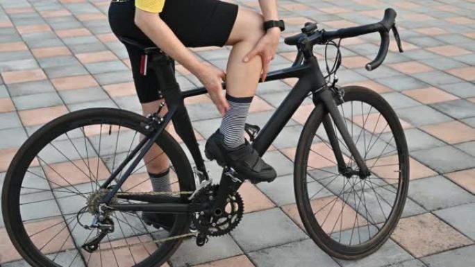 骑自行车的人因骑自行车而感到小腿拉伤。