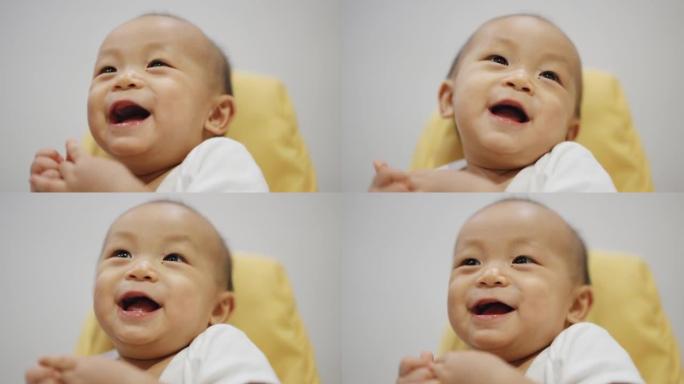有趣的男婴笑着看着相机。