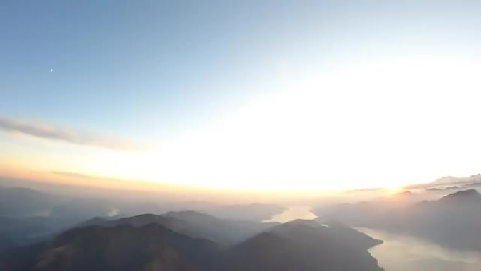 日落时分，天空潜水员在湖泊和山脉上方自由落体