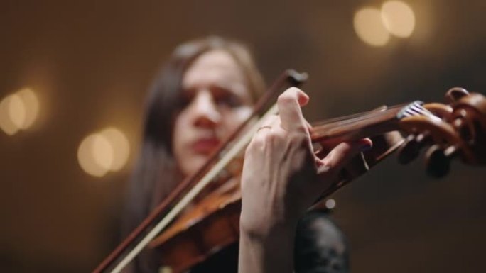 年轻女子手中的旧中提琴特写镜头，音乐家正在音乐会上演奏音乐