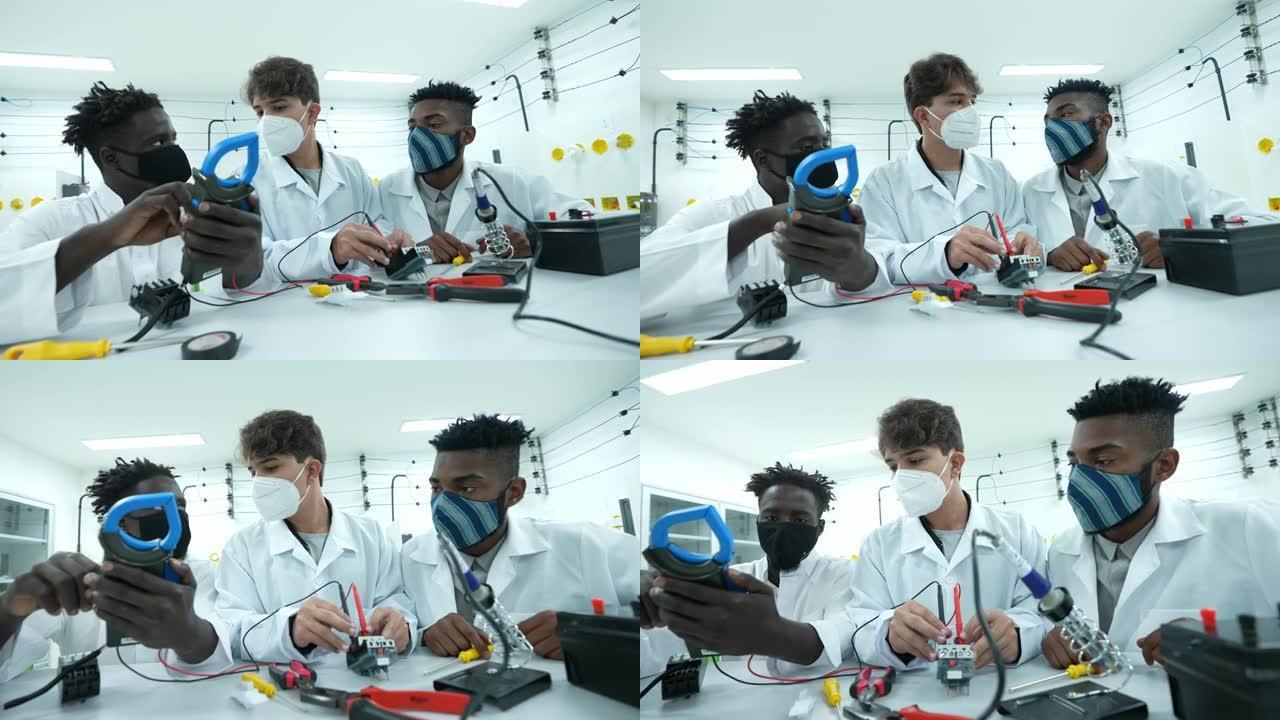 年轻男子在实验室里研究电子设备——戴着口罩