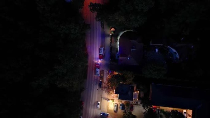一个消防队鸣笛并冲过交通的空中射击。晚上穿过十字路口的消防车。消防车工作人员。空中