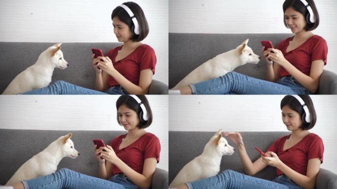 年轻女子在家和她的狗一起享受音乐。