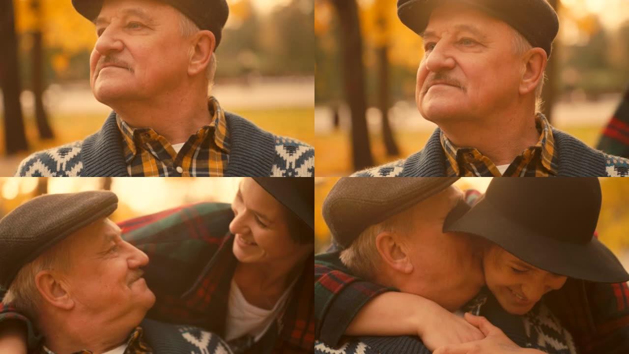 高级男子在城市公园等他的女儿。女儿在他们的会议上亲吻他的脸颊。美丽的秋天自然