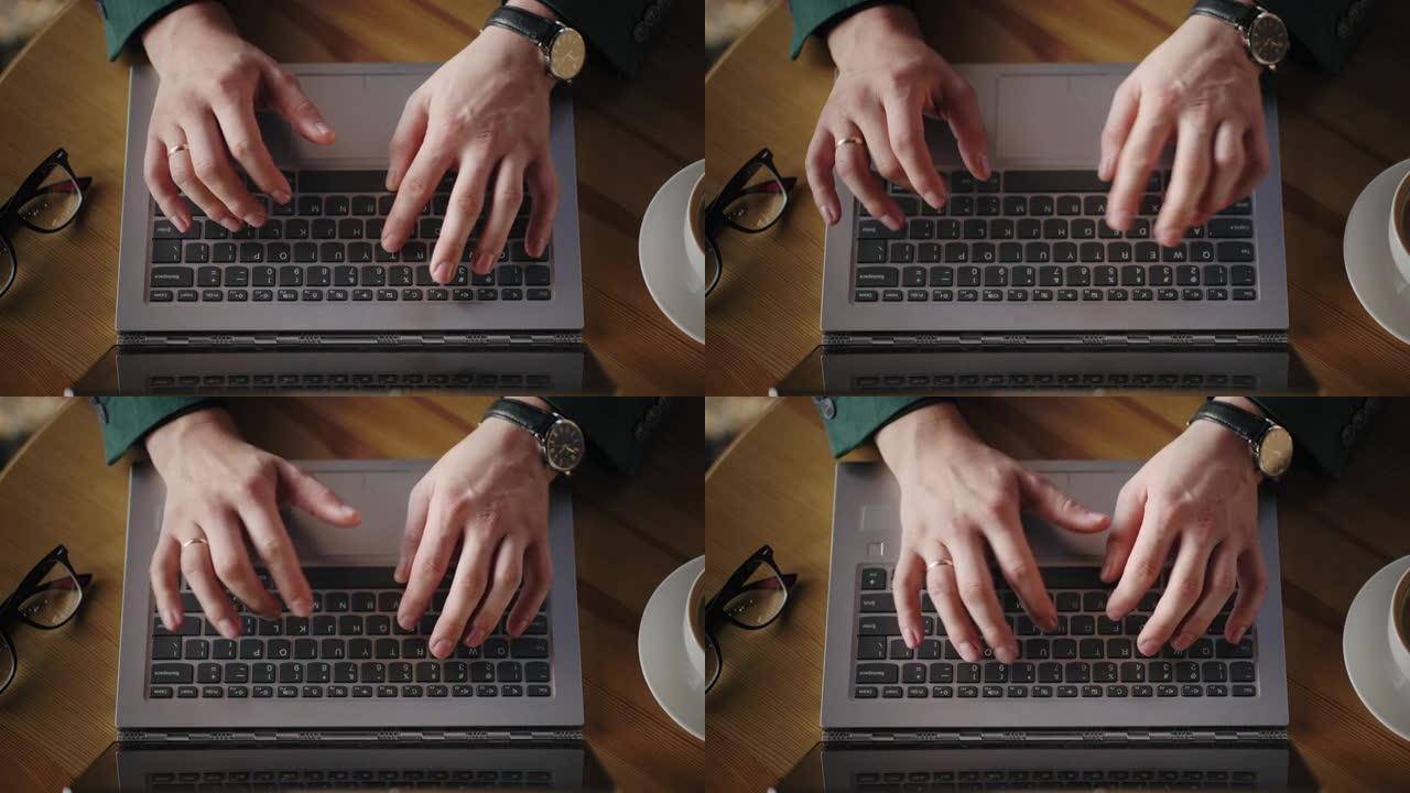 双手触摸笔记本电脑键盘在办公室打字的俯视图。创意设计师的整个工作日。在他的台式电脑上工作，喝咖啡，去