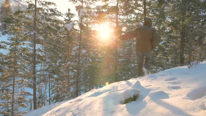男子在冬季森林中穿越积雪