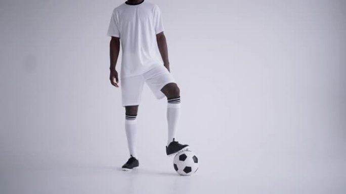 黑人足球运动员在工作室里与球合影，背景为白色，前锋肖像