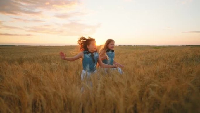 夕阳下的麦田里的孩子，两个可爱的女孩在金色的麦田里奔跑和玩耍