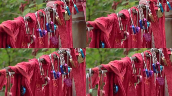 中国陕西寺庙的红丝带和挂锁绑在链条上。