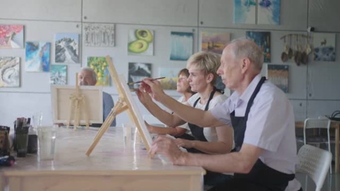 老师在绘画课程中展示了一群退休老人的朋友。一群老年男女相聚微笑