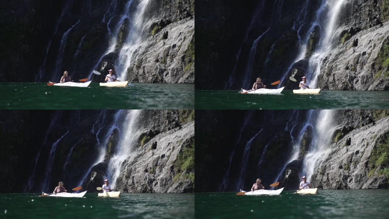 两名女性皮划艇运动员在瀑布附近的水面上