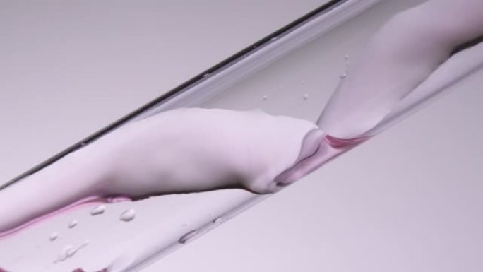 Slo-mo粉红色液体在玻璃管中流动螺旋