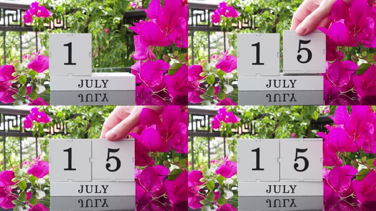 一个木制日历，有一个重要的活动，7月15日在一张有芙蓉花的桌子上，女人的手在日历上设定了日期。将日历