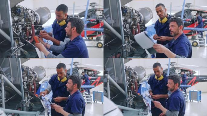 DS男性航空机械师在高级机械师的帮助下在直升机发动机上工作