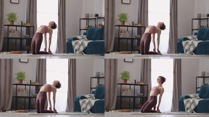 家庭健身在舒适的公寓里，女人早上训练，做伸展运动，保持健康
