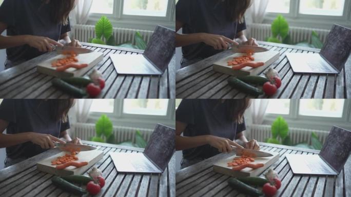 年轻女子在餐桌上切碎胡萝卜