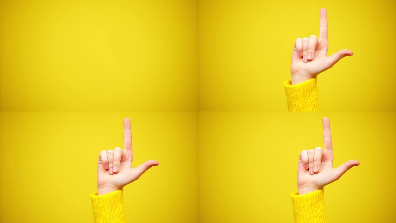 苗条的女性高加索人举手的特写镜头指向黄色背景。面目全非的女人有个主意。创造力和灵感概念。