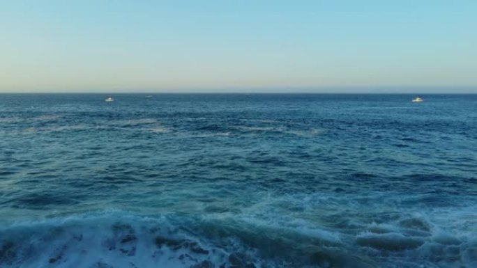 空中无人机在日出时在海滩附近拍摄海浪