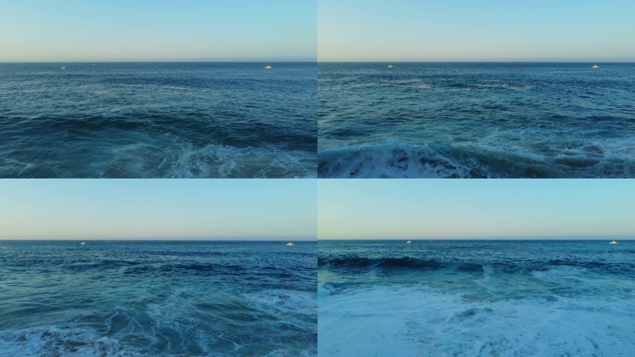 空中无人机在日出时在海滩附近拍摄海浪