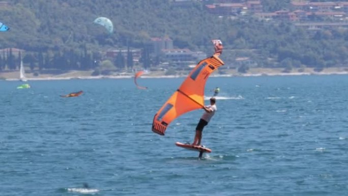 在刮风的晴天，湖上的一群机翼冲浪者的景色