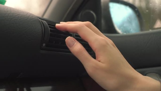 汽车司机用暖空气在车里暖手的特写镜头，