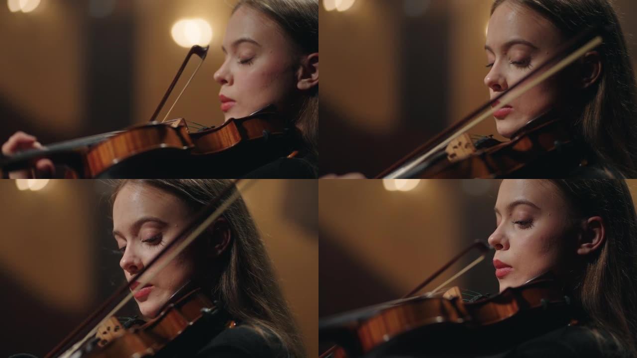 迷人的女小提琴手在爱乐音乐厅演奏经典音乐，特写女人肖像