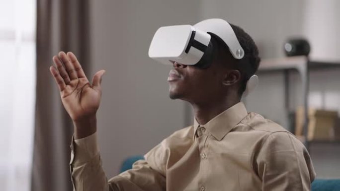 美国黑人男子正在用手刷虚拟屏幕，使用头戴式显示器，用现代小工具描绘人的肖像