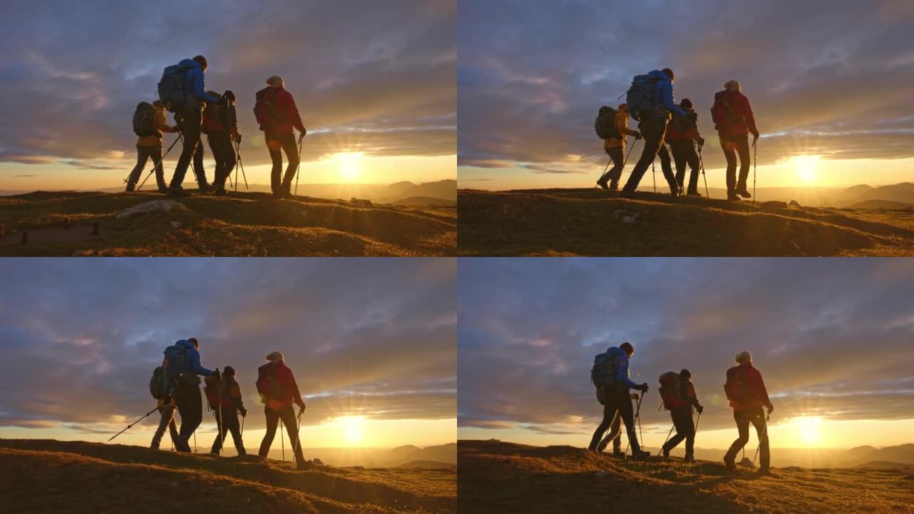 空中SLO MO四名徒步旅行者在日落时走在山顶上