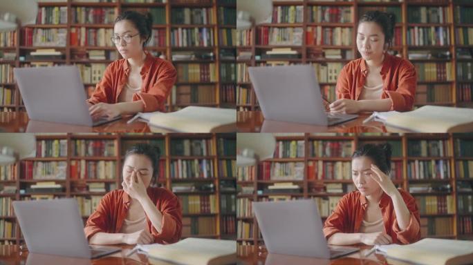 疲倦的女作家脱下眼镜，在笔记本电脑上休息，眼睛疲劳
