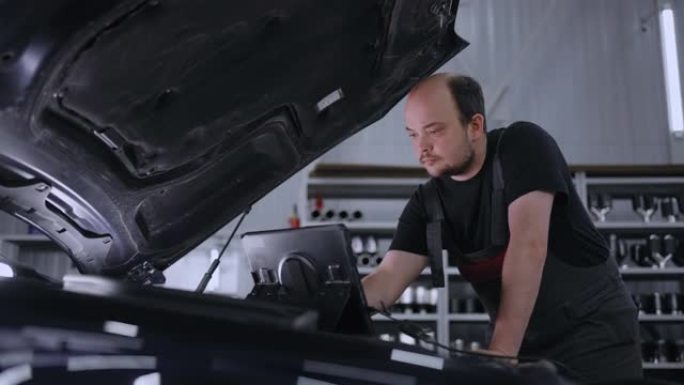 男性机械师使用带有增强现实诊断软件的平板电脑。专家检查汽车，以发现发动机舱内的损坏部件。现代汽车服务