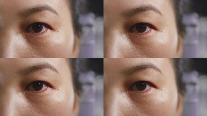 一个亚洲女人眨眼的SLO MO LD棕色眼睛
