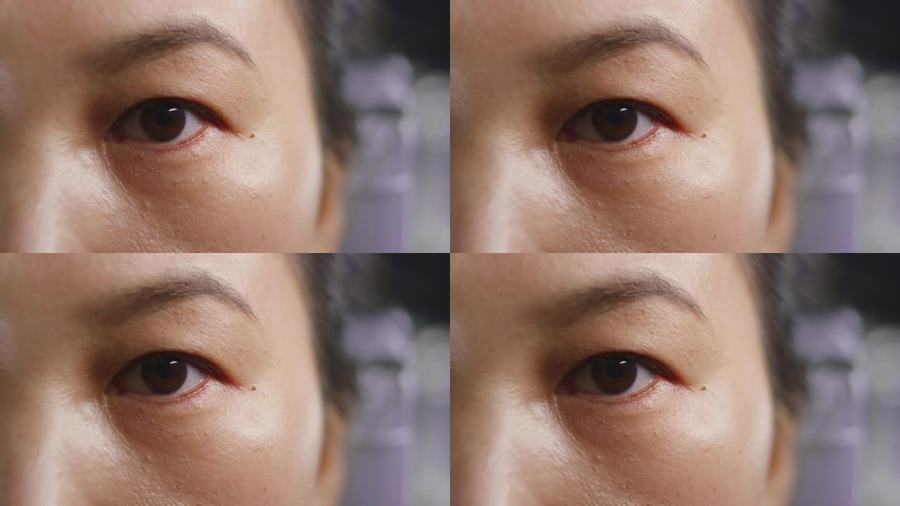 一个亚洲女人眨眼的SLO MO LD棕色眼睛