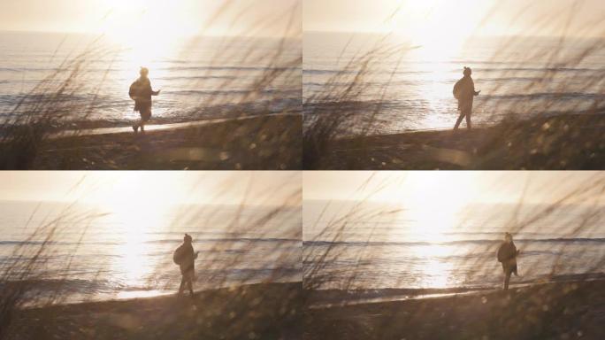 海滩上的女人剪影: 冬天的海洋日落