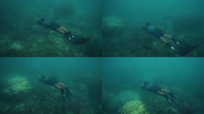 潜水员看着礁石上的鱼