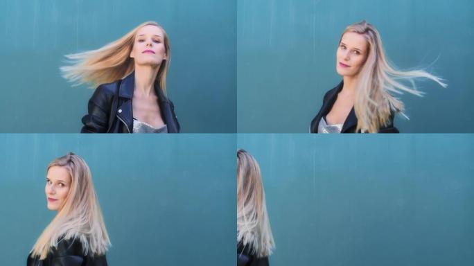 女人在蓝色的墙上摆姿势。扔漂亮的头发
