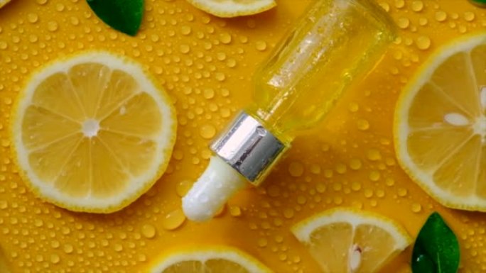柠檬精油在黄色背景与水滴。选择性聚焦。食品。