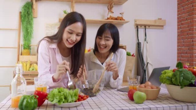 两名亚洲妇女在厨房里做沙拉健康的蔬菜烹饪