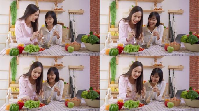 两名亚洲妇女在厨房里做沙拉健康的蔬菜烹饪