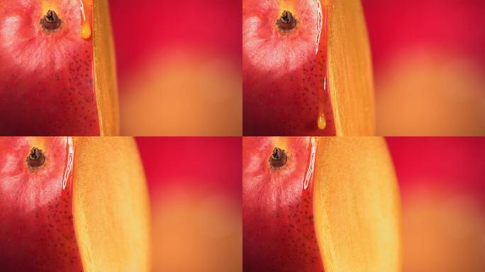 一滴芒果汁从旋转减半的芒果王表面流下。慢动作