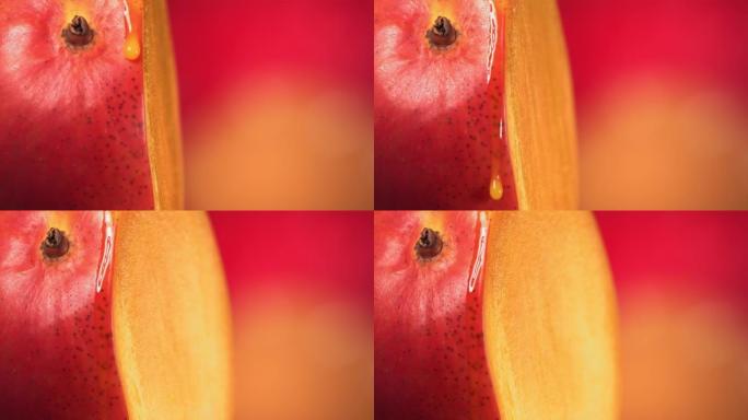 一滴芒果汁从旋转减半的芒果王表面流下。慢动作