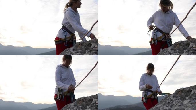 女性攀岩者在攀爬时整理装备，向外看